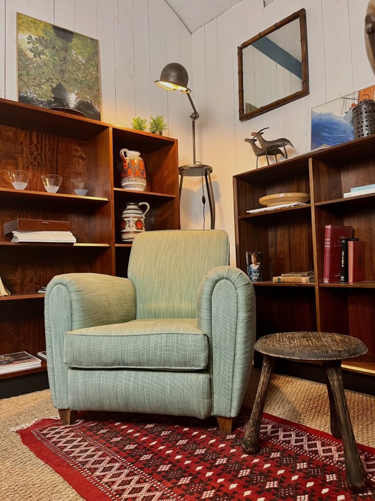 Fauteuil vintage et étagères en bois dans la boutique d’antiquités artisanales HDÉ