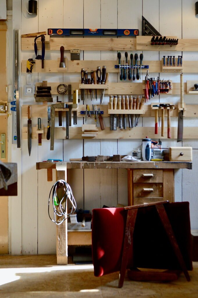 Mur d’outils d’ébénisterie dans un atelier artisanal en bois clair